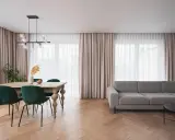 Jasne zasłony i zasłony w kolorze pudrowego różu tworzą przytulną atmosferę w salonie.