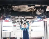 Mecánica revisa el coche en elevador. ¡Un buen comienzo para abrir taller mecánico!