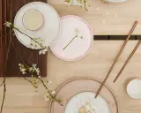 Vårens inspiration: tallrikar, ätpinnar och körsbärsblommor på träbord.