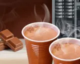 Ciepła czekolada z automatu, obok kostki czekolady. Zastanawiasz się, ile kcal ma czekolada z automatu?