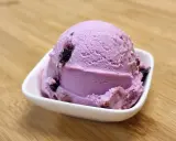 Une boule de glace violette aux fruits, parfaite pour une recette glace amarena maison.