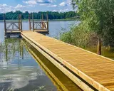 Drewniane pomosty nad jeziorem, idealne na letnie wypady nad wodę. Stawy komercyjne zapraszają do relaksu.