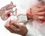 Ból lewej ręki może być objawem problemów z sercem. Rysunek serca i EKG na tle dłoni.