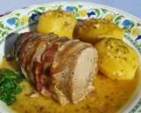 Solomillo al ajillo envuelto en bacon, servido con patatas doradas y perejil fresco. ¡Un plato delicioso!