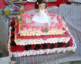 Un pastel de xuxes con una muñeca en la cima, decorado con malvaviscos, gominolas y caramelos.
