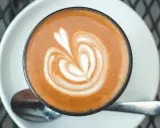 Ein Cortado mit Latte Art, das Herzsymbol auf dem Schaum, im Vergleich zu einem Cappuccino.