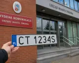 Tablica rejestracyjna CT 1234S przed Wydziałem Komunikacji Urzędu Miasta Torunia.