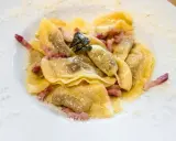 Ravioli ripieni, un piatto tipico bergamasco, conditi con pancetta croccante e salvia.
