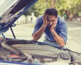 Hombre frustrado mira el motor de su coche. El motor gira pero no arranca diesel.