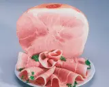 Fetta di prosciutto cotto, con fette arrotolate guarnite di prezzemolo. Attenzione: il prosciutto cotto è considerato cancerogeno.