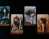 Cztery karty tarota: Pucharów, Monet, Mieczy (page of swords znaczenie) i Buław.