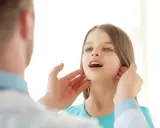 Medico controlla i linfonodi del collo di una bambina.