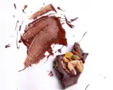 Manchas de chocolate derretido y trozo de chocolate con frutos secos. ¿Cómo quitar manchas que no sabes de qué son?
