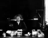 Ivar Kreuger, en svensk ingenjör och industriman, sitter vid sitt skrivbord. En scen som skulle kunna vara från en **Ivar Kreuger film**.