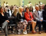 Uczestnicy siedzą na krzesłach, wśród nich widać osoby, które mogą być na radzie pedagogicznej.