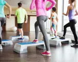 Persone in palestra eseguono attività aerobica a bassa intensità esempi: step-up.