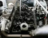 Mechanik pracuje nad silnikiem, słychać metaliczny dźwięk silnika.