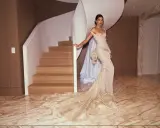 Kendall Jenner in a flowing gown, posing by a spiral staircase, a vision of Met Gala elegance.