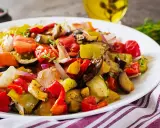 Un piatto colorato di verdure miste, pomodori, melanzane e peperoni, che evoca i sapori dei piatti tipici siracusani.