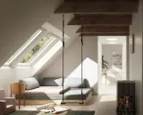 Aménagement d'un grenier lumineux avec balançoire, lit bas et coin jeux. Idées pour comment aménager un grenier en espace cosy.