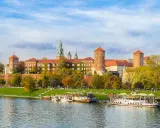 Wawel w jesiennej odsłonie, z łodziami na Wiśle. Poznaj ciekawostki o Krakowie, spacerując brzegiem rzeki.
