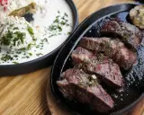 En saftig argentinsk grillfest med perfekt stekt kött och en krämig rätt med örter.