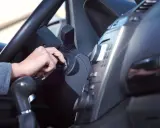 Mano girando la llave de contacto. Es malo tener el coche arrancado mucho tiempo, consume combustible y contamina.