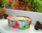 Uroczy koszyczek z motywem kwiatów i motyli, wykonany techniką decoupage na plastiku. Idealny do przechowywania drobiazgów.