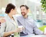 Pareja sonriente compartiendo un café, un ejemplo de comunicación efectiva.
