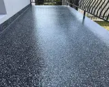 Nowy, błyszczący balkon z żywicą epoksydową. Ciemna posadzka z drobinkami tworzy nowoczesny wygląd.