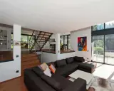 Moderne Wohnlandschaft mit offenem Treppenhaus und Kunstwerk. Tolle split-level haus ideen für ein geräumiges Zuhause.