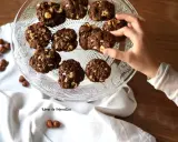 Délicieux cookies au chocolat et noisettes, parfaits pour savoir que faire avec un reste de ganache au chocolat. Une main en prend un.