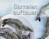 Gefrorene Garnelen auf einem Teller. Erfahren Sie, wie lange Garnelen zum Auftauen brauchen, um sie frisch zuzubereiten.