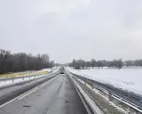 Zimowa trasa, śnieg przy drodze, drzewa bez liści. Nowy tomyśl trasa wita podróżnych.