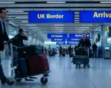 Podróżni z bagażami na lotnisku, kierujący się do UK Border. Zastanawiają się, ile alkoholu do UK mogą przywieźć.