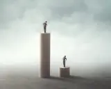 Due uomini su cilindri di legno. Uno è più alto, l'altro più basso. Il narcisista è geloso dell'altezza altrui.