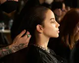 Stylista układa włosy modelki, ukazując olśniewające olaplex efekty: jedwabistość i blask.