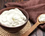Un bol de crème onctueuse, parfaite pour une crème diplomate, avec une cuillère en bois remplie de cette douceur.