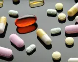 Varie pillole e capsule colorate, tra cui una grande capsula arancione trasparente. Un'immagine che fa riflettere sulla terapia biologica cos'è.