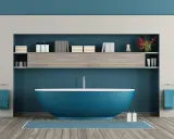 Un moderno bagno azzurro con vasca centrale, mensole piene di libri e flaconi, e due asciugamani blu appesi.