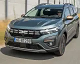 Zielony Dacia Jogger w ruchu drogowym. Sprawdź atrakcyjną dacia jogger cena i wybierz swój wymarzony model.