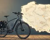 Czy rower elektryczny jest pojazdem mechanicznym? Ten rower z sakwami na tle mapy Polski sugeruje podróż po kraju.