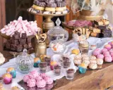 Una mesa dulce boda original con donuts, brownies, malvaviscos rosas y bolitas de colores.