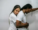 Una pareja se abraza con tristeza, reflejando el momento en que empiezan los problemas de pareja. Él se apoya en la pared, ella recuesta su cabeza en su hombro.