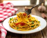 Un piatto di spaghetti alla carrettiera fumanti, conditi con pomodoro, aglio e prezzemolo, pronti per essere gustati.