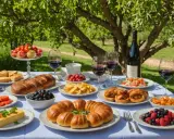 Un festin en plein air : pain, fruits, tartes et vin rouge, une véritable spécialité du Luberon sous les arbres.