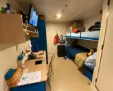 Cosa trovo in cabina Costa Crociere: letti a castello, scrivania con TV, valigie e un peluche.
