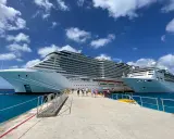 Persone camminano su un molo verso due enormi navi da crociera, pronte per imbarcarsi. Ecco come si sale su una nave da crociera!