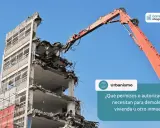 Grúa naranja realiza demoliciones de edificios. Se pregunta sobre permisos para demoler inmuebles.