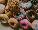 Kolorowe pączki z posypką, lukrem i cukrem pudrem. Zastanawiasz się, ile kalorii ma pączek?
